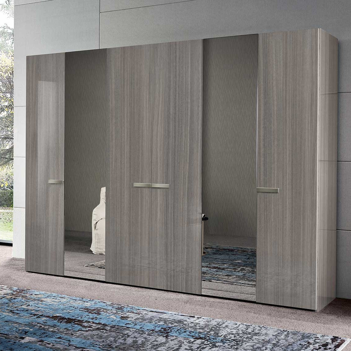 A modern, large grey wooden wardrobe with four sliding doors, two of which feature full-length mirrors. — Castle Furniture