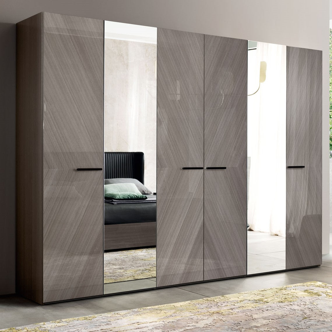A large modern bedroom wardrobe featuring sliding doors with a grey wood grain finish and integrated full-length mirrors. — C